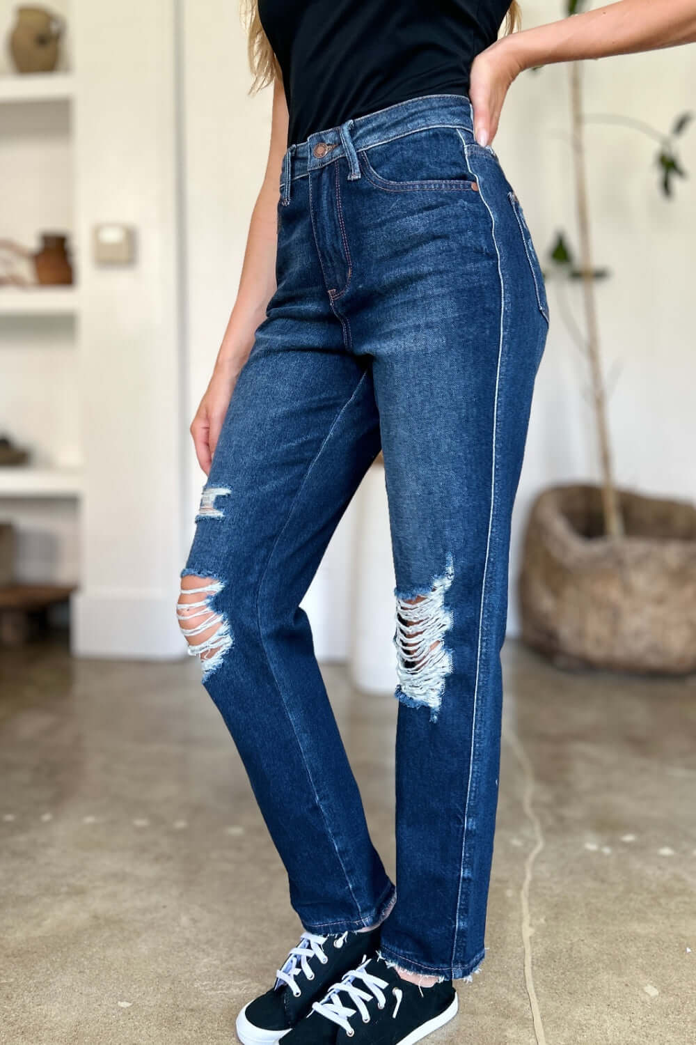 Woman wearing High Waist Rigid Magic Heavy Destroy Straight Judy Blue Jeans with heavy distressing and a stylish straight-leg design.