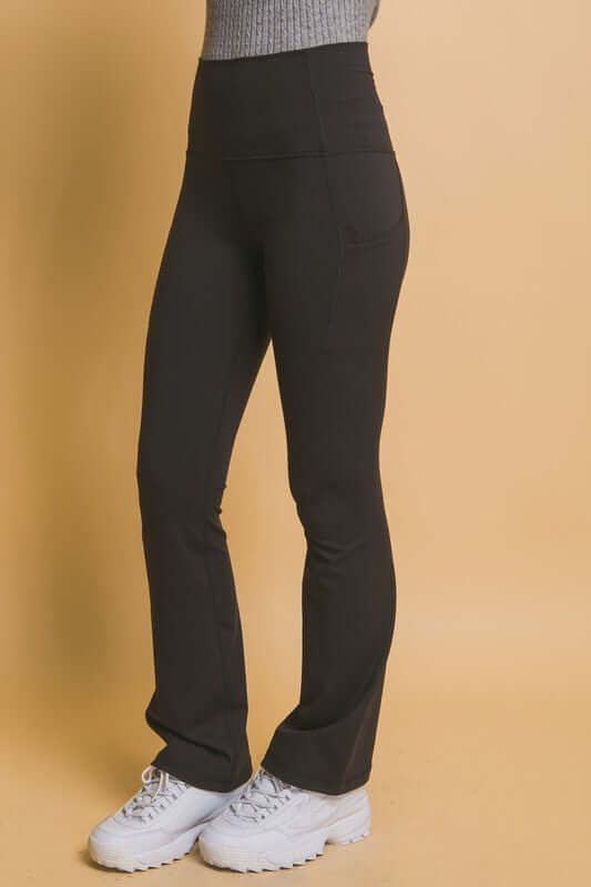 High waist flare active leggings with side pockets, ideal for workouts and everyday wear, styled with a cozy sweater.