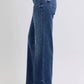 Side view of Judy Blue full-size raw hem mid-rise jeans showcasing a frayed edge and stylish fit.