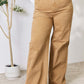 Woman wearing Risen Jeans Fringe Hem Wide Leg Jeans, showcasing high-waisted fit and trendy wide-leg design.