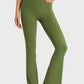 Model wearing Millennia Elastic Waist Flare Yoga Pants in green, showcasing comfort and style for yoga and workouts.