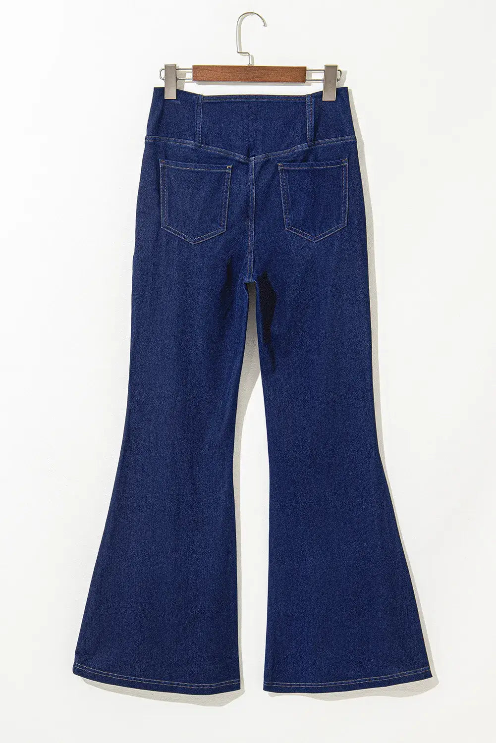 Back view of blue asymmetric waist flare jeans for women showing pocket details and unique flared design.