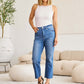 Woman wearing Mini Mia Full Size Tummy Control High Waist Jeans in living room. RFM Jeans.