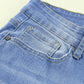 Close-up of Bella Road Button-Fly Distressed Raw Hem Flare Jeans in light blue denim showing back pocket and seam details.