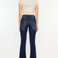 Woman wearing Kancan mid-rise slim flare jeans in dark stone wash, showcasing stylish back view and flattering silhouette.