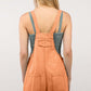 Woman wearing a trendy washed frayed hem denim overall with side and back pockets; perfect for casual outings and vintage fashion lovers.