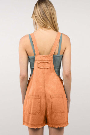 Woman wearing a trendy washed frayed hem denim overall with side and back pockets; perfect for casual outings and vintage fashion lovers.