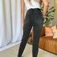 Woman wearing RFM Full Size High Rise Tummy Control Skinny Jeans in black, showing back view and fit.