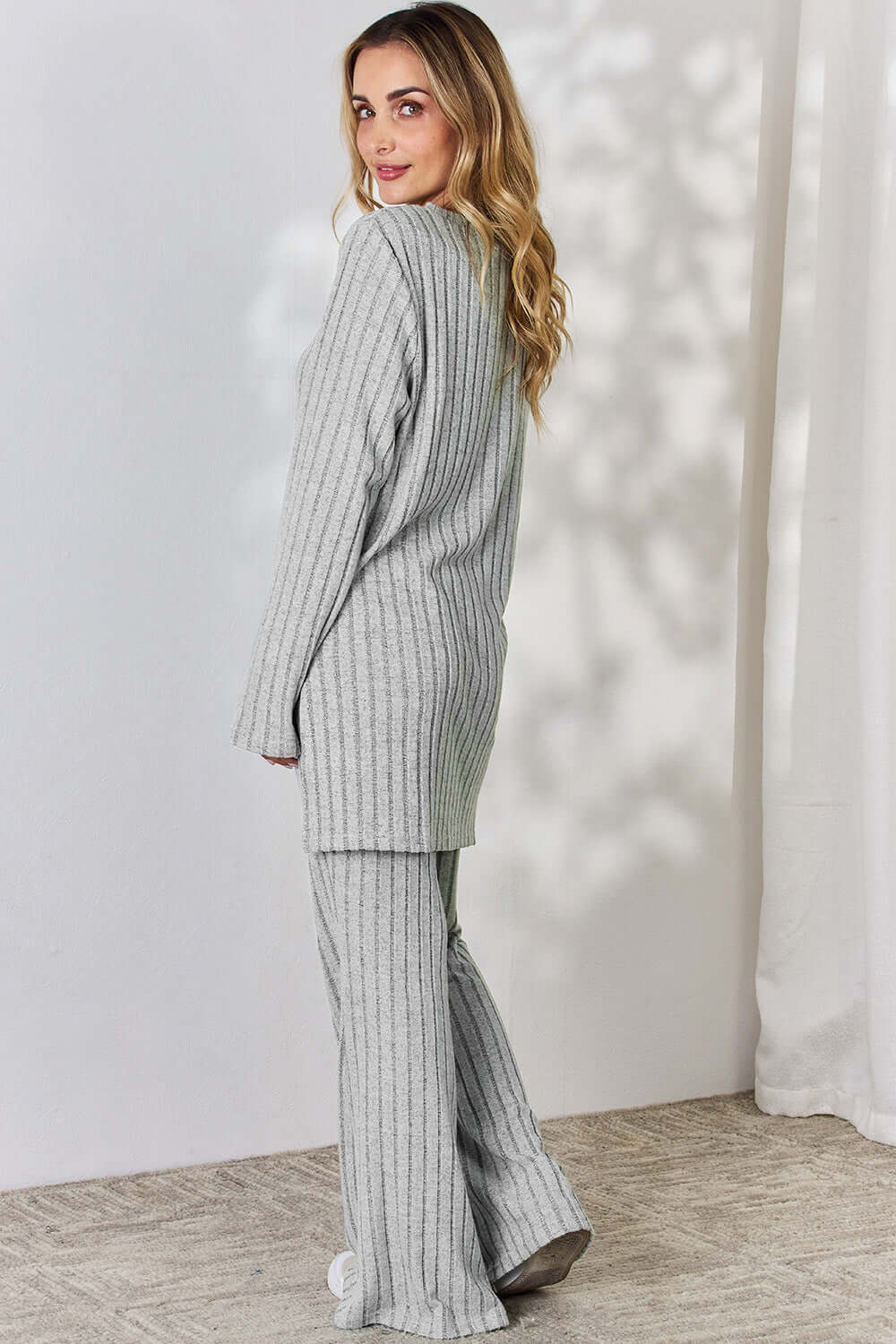 Woman wearing gray Ribbed High-Low Top and Wide Leg Pants Set, slightly stretchy two-piece outfit made of polyester-elastane blend.