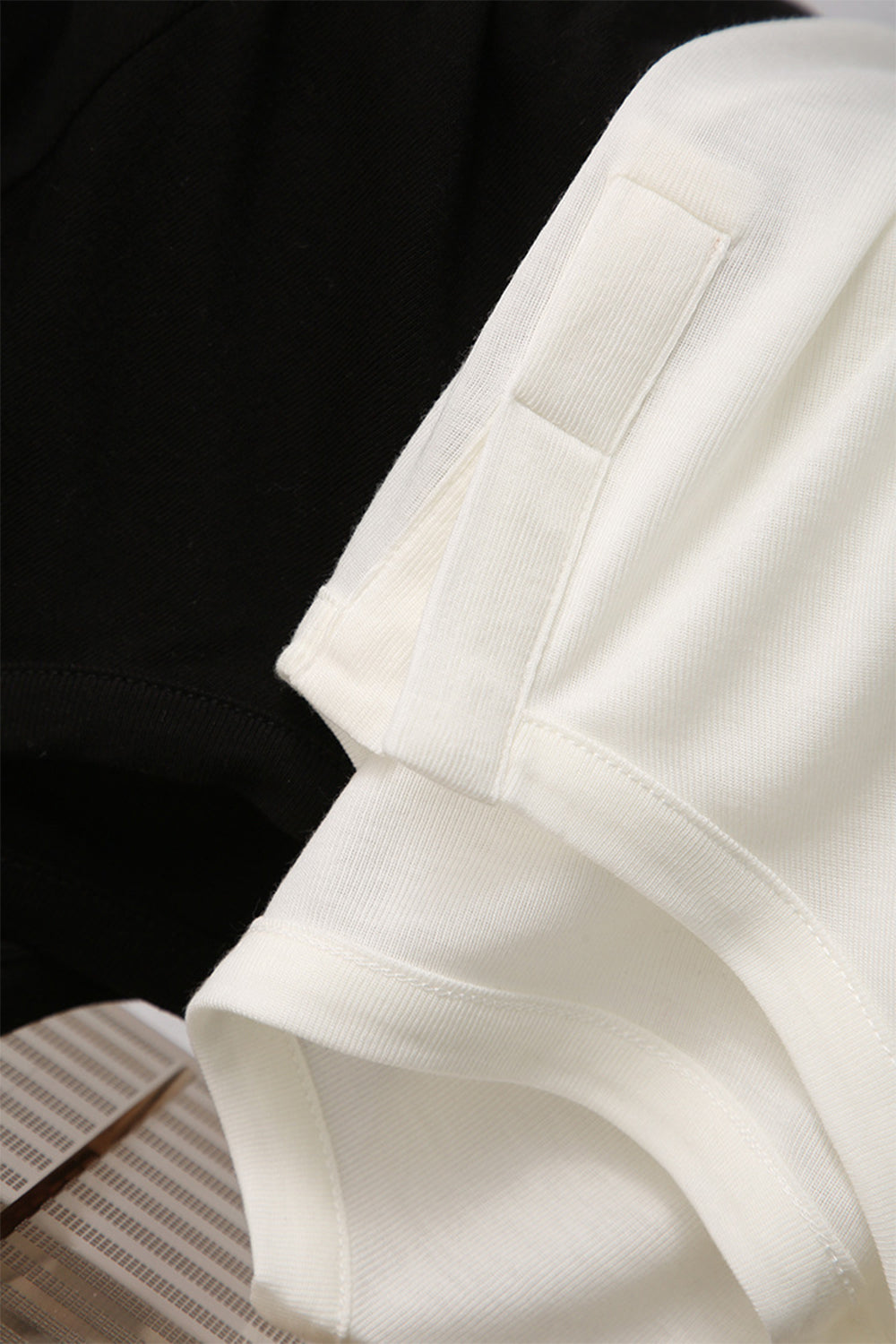 Close-up of Basic Bae Notched Long Sleeve T-Shirt in black and white, showcasing the unique neckline and soft fabric.