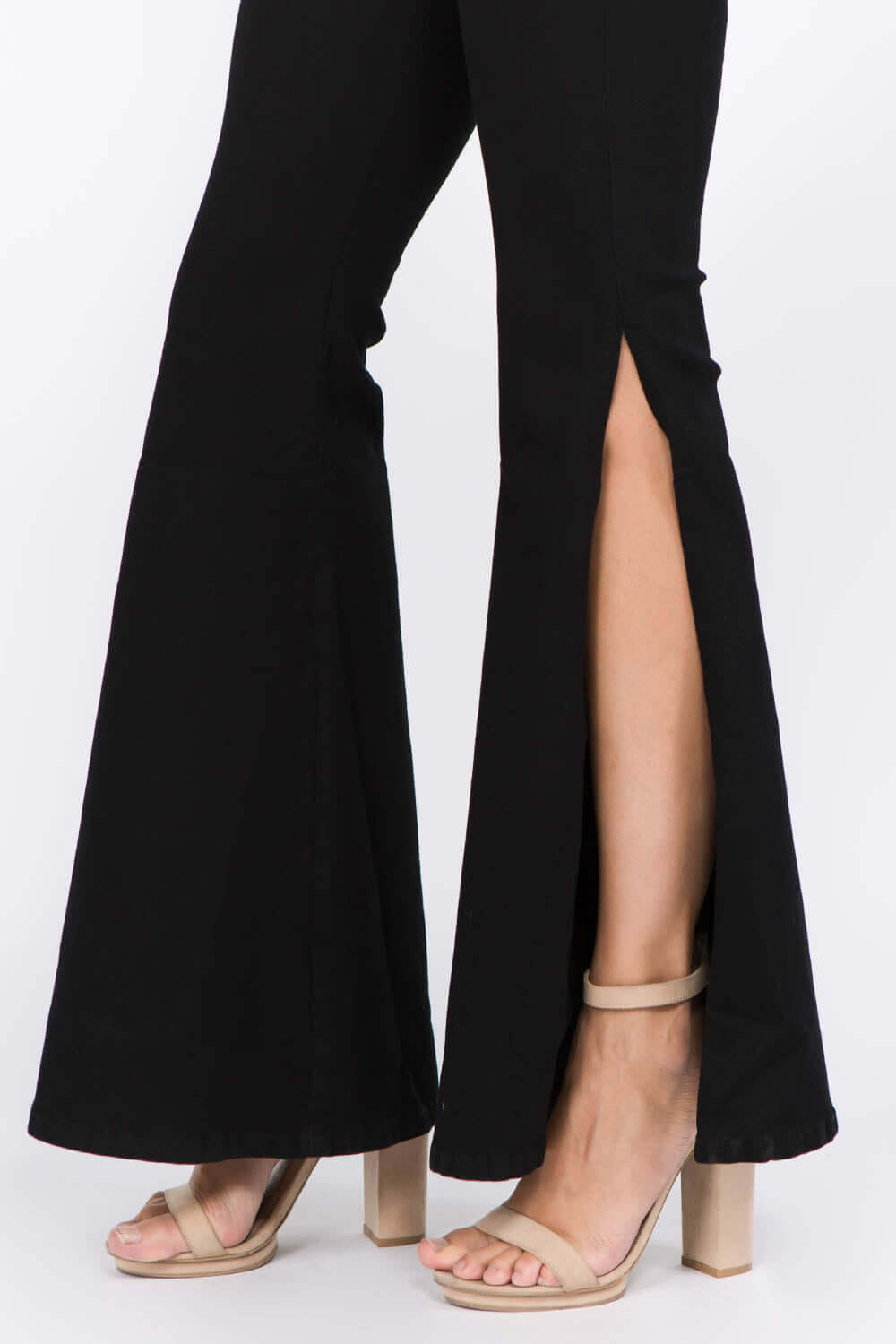 American Bazi side slit flare jeans in black paired with nude block heels, showcasing trendy side slits and flattering flare legs