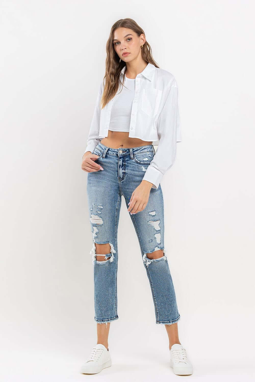 Woman wearing Lovervet Full Size High Rise Slim Straight Jeans with a white cropped top and white sneakers.