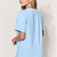 Woman wearing a light blue MAMA Round Neck Short Sleeve T-Shirt made from 94% cotton and 6% spandex, styled with jeans.