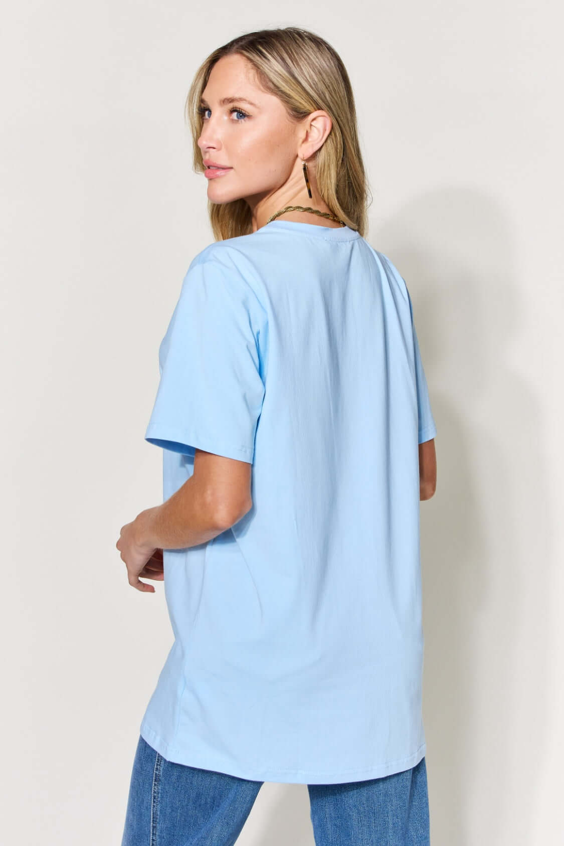 Woman wearing a light blue MAMA Round Neck Short Sleeve T-Shirt made from 94% cotton and 6% spandex, styled with jeans.