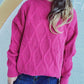 Woman wearing Bella Road Diamond Round Neck Long Sleeve Sweater in pink with unique diamond pattern, paired with blue jeans.