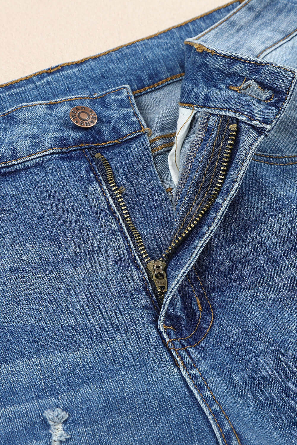 Close-up of Baeful Checkered Patchwork Mid Waist Distressed Jeans zipper and button details in flat lay style.