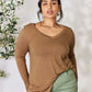 Woman wearing a brown long sleeve V-neck top made of luxurious rayon, paired with green pants, showcasing a flattering and sophisticated look.