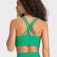 Back view of a woman wearing a green crisscross scoop neck active tank, showcasing stylish design and comfort.