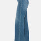 Judy Blue high-waist tummy control jeans with raw hem in side view, showcasing trendy style and comfortable fit.