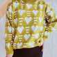 Woman wearing Bella Road Heart Contrast Long Sleeve Dropped Shoulder Sweater with heart pattern design in green and white.