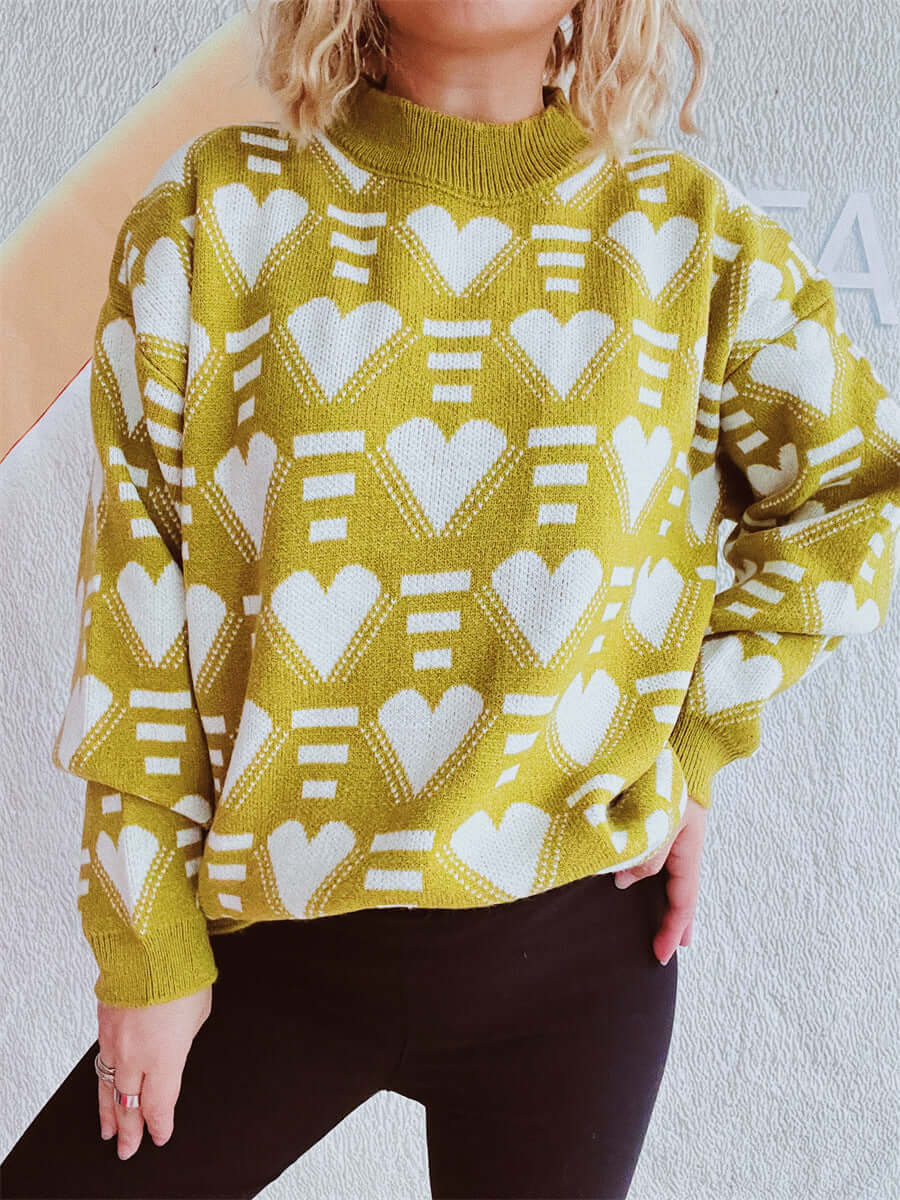 Woman wearing Bella Road Heart Contrast Long Sleeve Dropped Shoulder Sweater with heart pattern design in green and white.