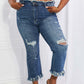 Woman modeling Undone Chic Straight Leg Jeans by Risen Jeans with distressed details, raw hem, and cropped length, paired with a white crop top.