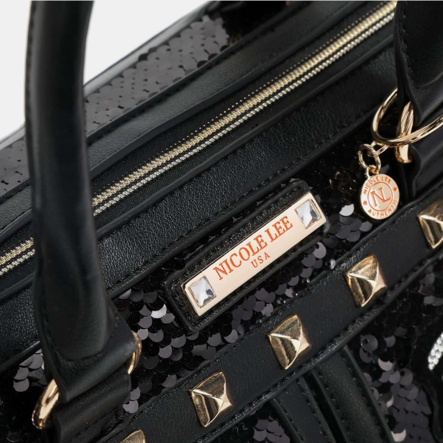 Close-up of Nicole Lee USA sequin patch Boston bag with vegan leather accents and stud details on a medium-sized bag