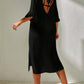 Woman wearing backless black slit V-neck flounce sleeve cover-up with tied details, made of sheer polyester material.