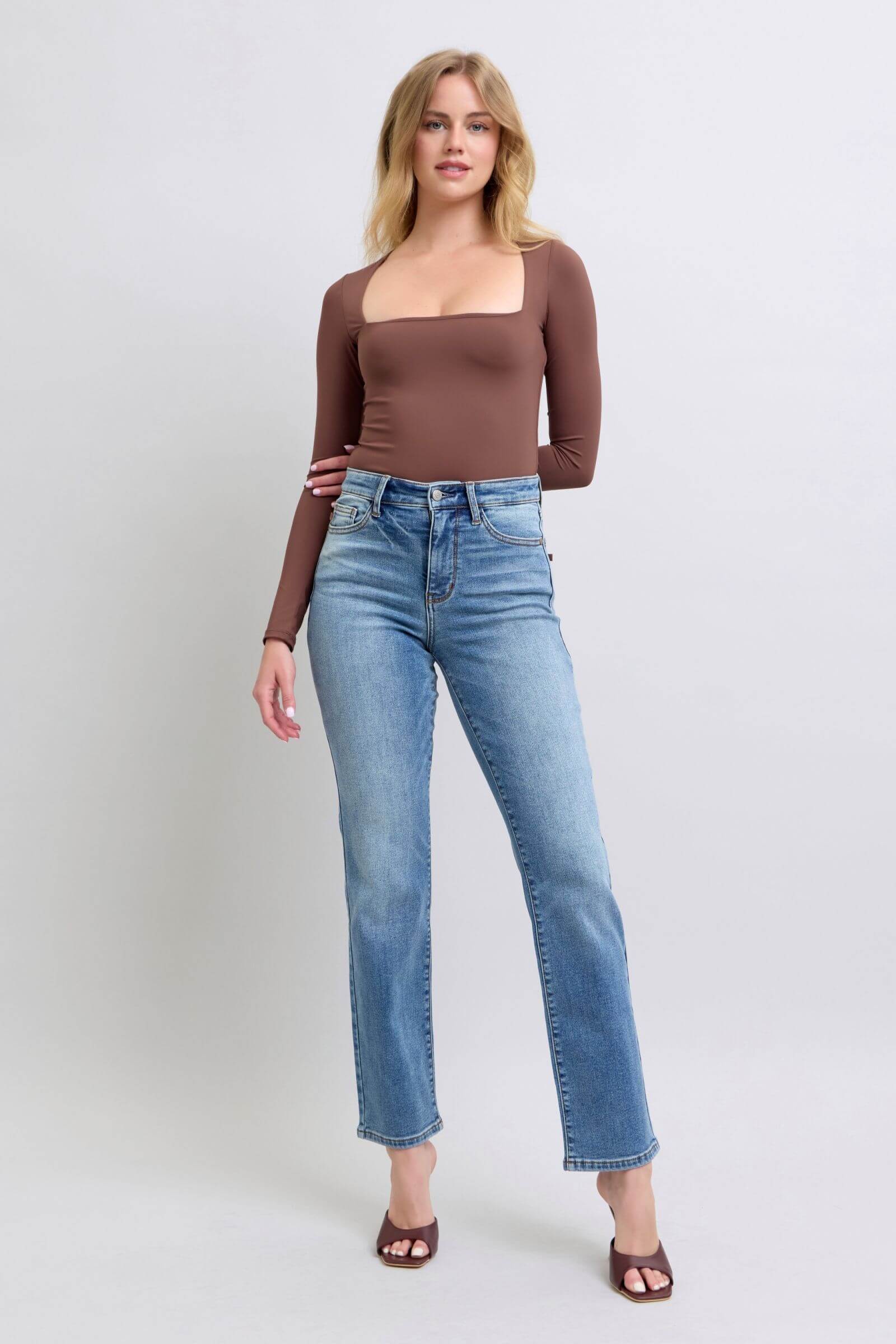 Model wearing Judy Blue vintage wash thermal straight jeans, showcasing a classic fit and stylish brown long-sleeve top.