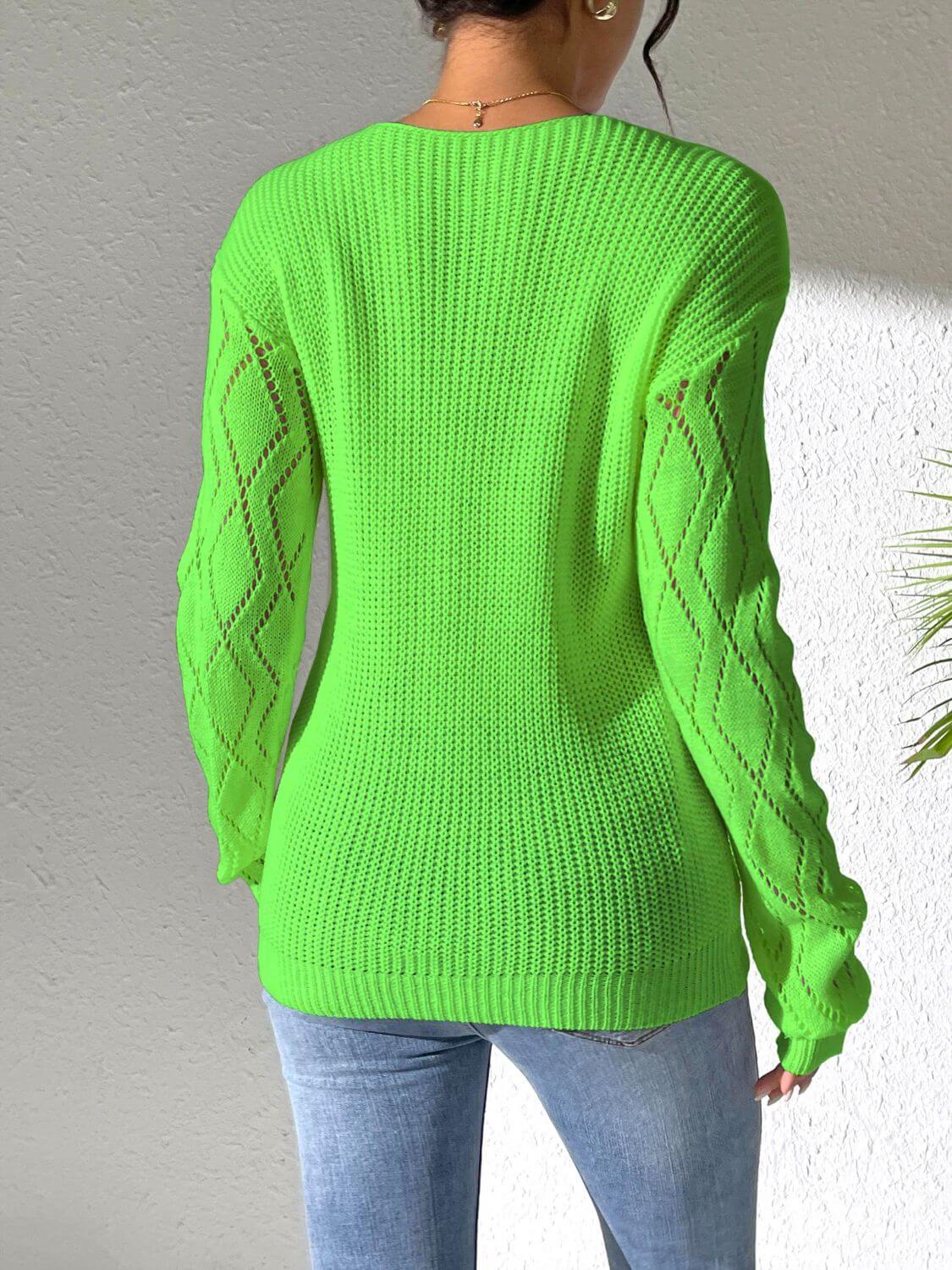 Woman wearing vibrant green openwork long sleeve sweater with jeans, showcasing stylish design and cozy texture.