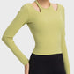 Stylish woman wearing a green Millennia halter neck long sleeve sporty top, perfect for workouts and staying comfortable.