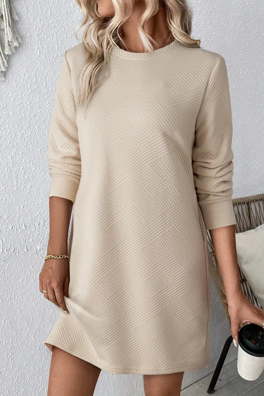 Bella Road textured round neck long sleeve mini dress in beige, showcasing a stylish pattern and comfortable fit.