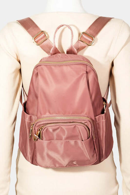 Stylish pink nylon backpack bag with multiple pockets and adjustable straps, perfect for daily adventures.