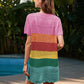 Woman wearing Bella Road Swim Openwork Cover-Up with rainbow stripes by a pool, showcasing summer style and comfort.