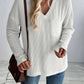 Woman wearing Double Take Pocketed Textured V-Neck Long Sleeve T-Shirt in white with jeans and a shoulder bag