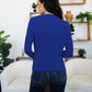 Woman in French Blue FAM-FAM Ruched Mock Neck Long Sleeve T-Shirt, styled with jeans, stands in a cozy room.