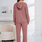 Woman wearing dusty pink Bella Road hoodie and pants set, featuring a relaxed fit. Perfect for cozy lounging or stylish errands.