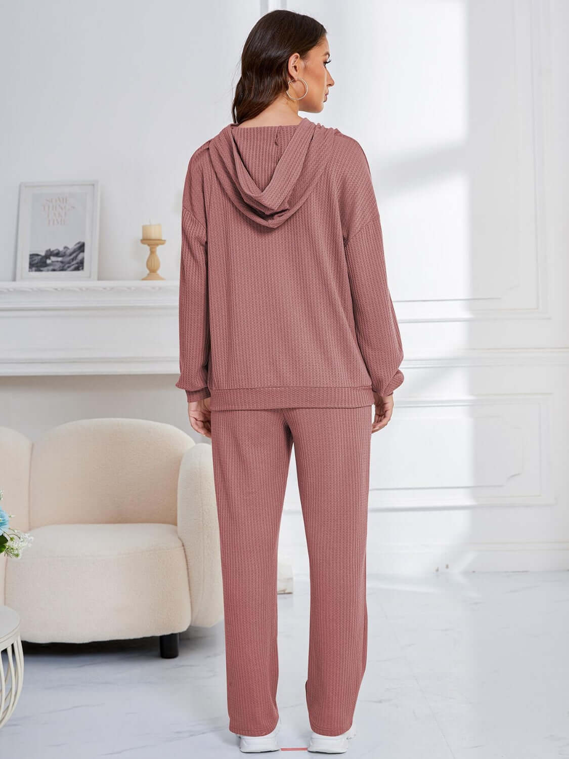 Woman wearing dusty pink Bella Road hoodie and pants set, featuring a relaxed fit. Perfect for cozy lounging or stylish errands.