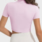 Stylish woman wearing a pink quarter zip short sleeve active t-shirt, showcasing a sleek back design for comfort and flexibility.