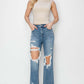 Woman wearing High Rise Distressed Crop Straight Jeans by Risen Jeans, showcasing trendy ripped details and a flattering high-waisted fit