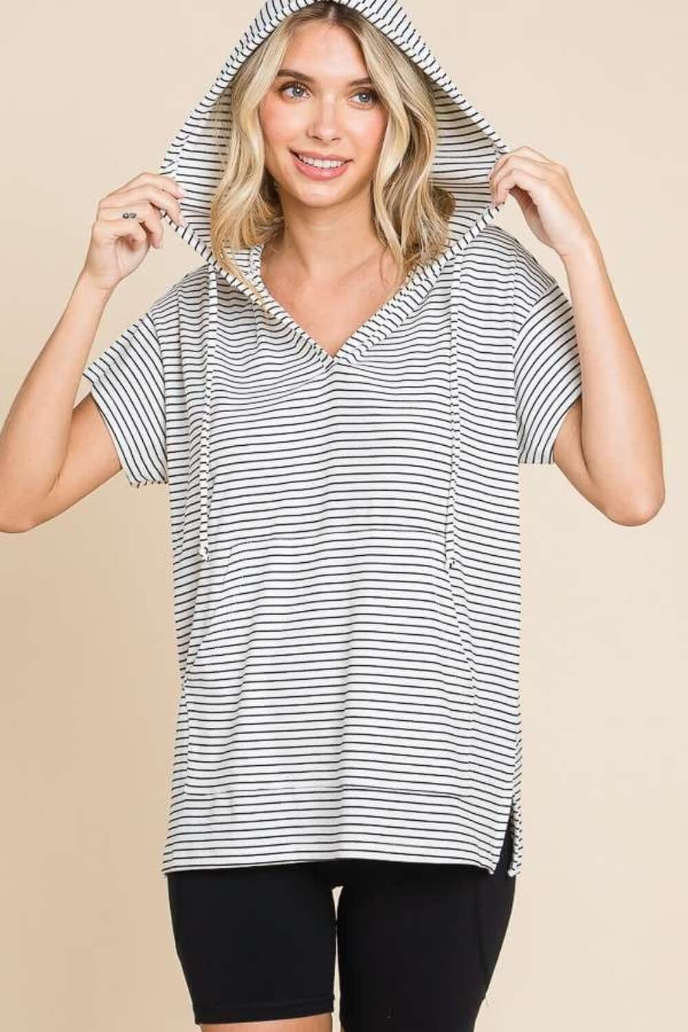 Woman wearing a casual striped short sleeve hooded top, showcasing its sporty and trendy design ideal for everyday wear in various seasons.