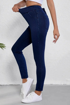 Woman wearing dark blue skinny jeans with pockets designed for petite sizes, showing sleek fit and style.