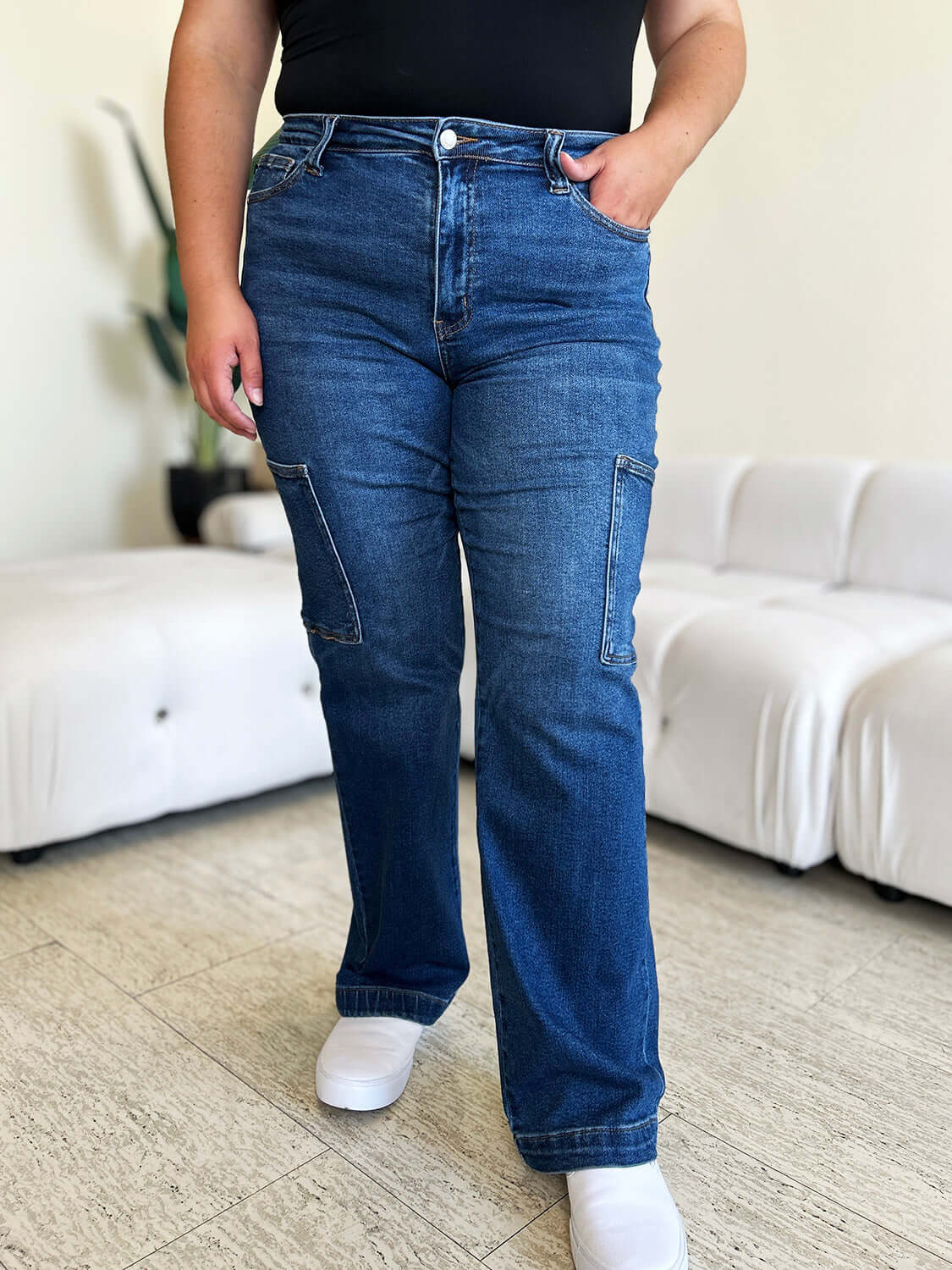 Woman wearing Judy Blue High Waist Straight Cargo Jeans standing in a modern living room.