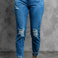 Stylish distressed cropped jeans with slightly stretchy material, solid pattern, and casual look, modeled in a studio setting.