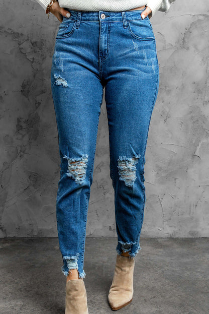 Stylish distressed cropped jeans with slightly stretchy material, solid pattern, and casual look, modeled in a studio setting.