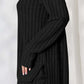 Ribbed black high-low top and wide leg pants set in slightly stretchy fabric, side view of model wearing two-piece ensemble.