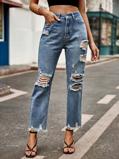 Woman wearing Bella Road distressed raw hem jeans with pockets, slightly stretchy denim, buttoned fly, and stylish ripped details.