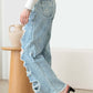 Woman wearing Distressed Frayed Hem Flare Jeans with ripped edges, showcasing trendy style and classic 5 pockets.