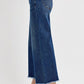 Wide leg raw hem jeans with attached buckle, showcasing a trendy and relaxed fit, paired with stylish heels.