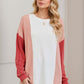 Woman wearing Double Take Texture Contrast Round Neck Long Sleeve T-Shirt in trendy color combo. Fashionable casual style.